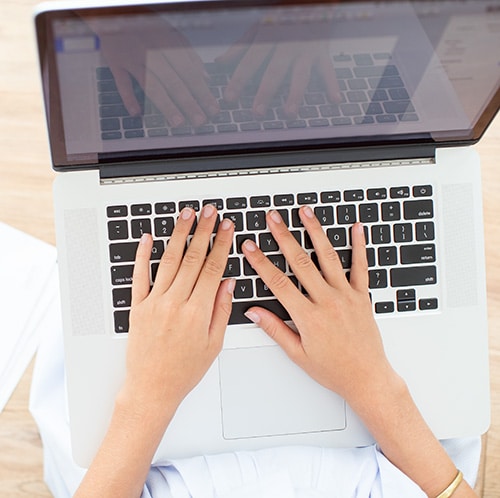 Une femme pianotant sur son ordinateur